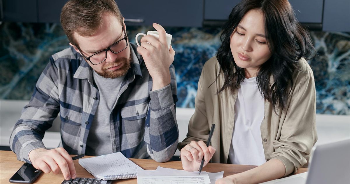 Couple reviewing bills and budgeting to manage debt in Canada