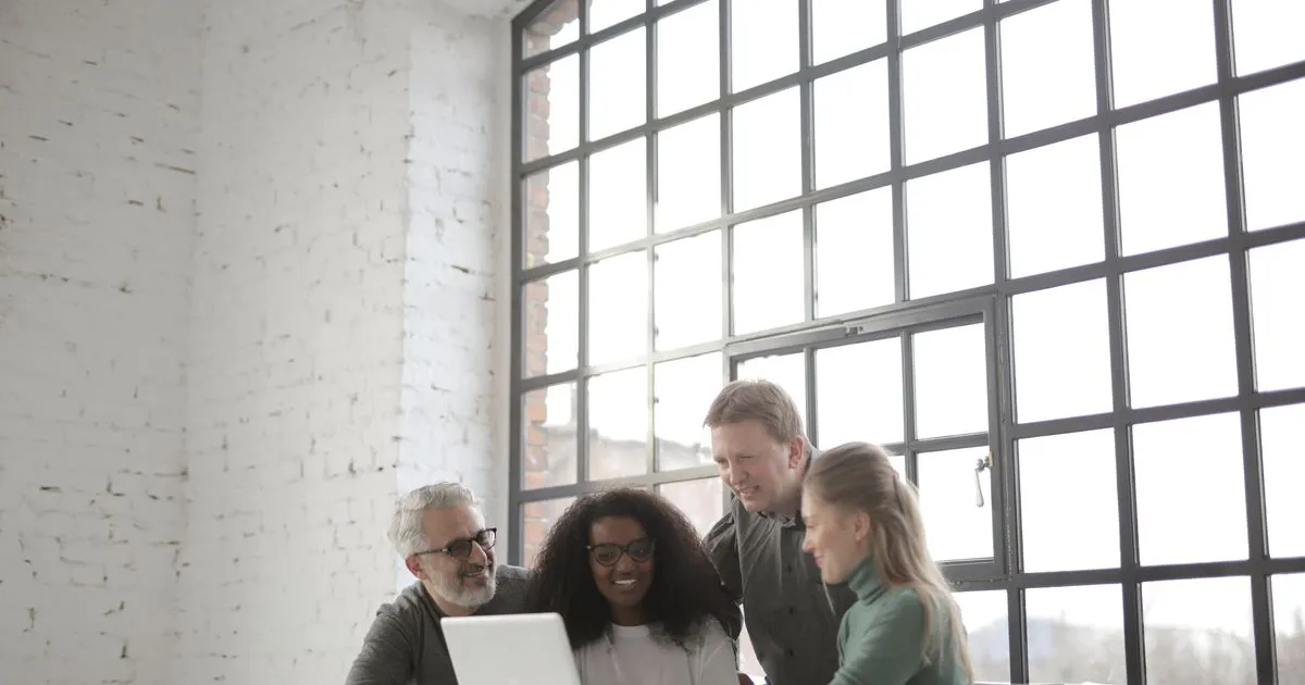 Team reviewing credit guides together at a laptop