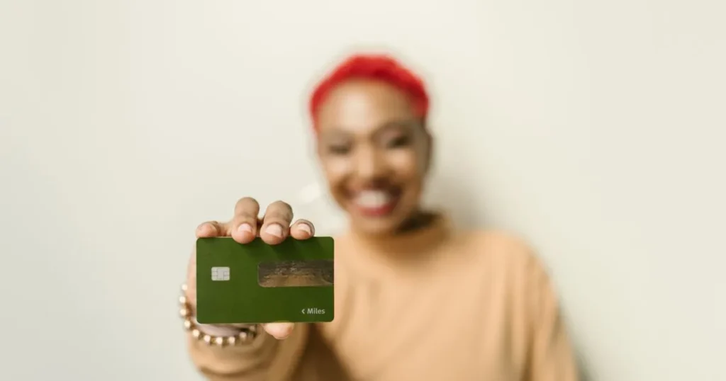 Smiling woman holding a credit card after learning how to build credit in Canada