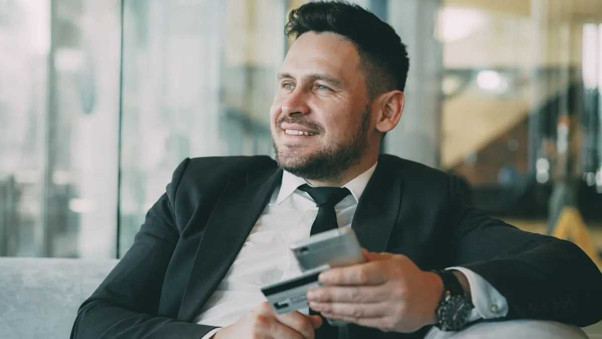 Newcomer holding his first secured credit card while building credit for newcomers in Canada