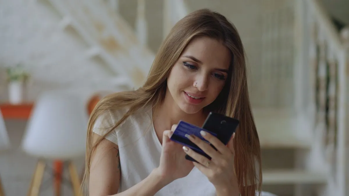Woman paying a bill on time on her phone to build credit