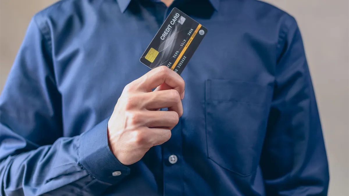 Man holding a secured credit card to rebuild his credit in Canada