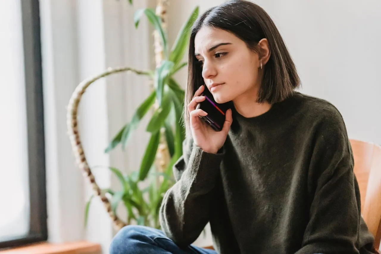 Woman calmly handling a debt collector phone call at home in Canada