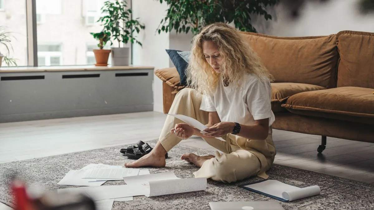 Woman reviewing her debts and paperwork at home before choosing a debt relief option