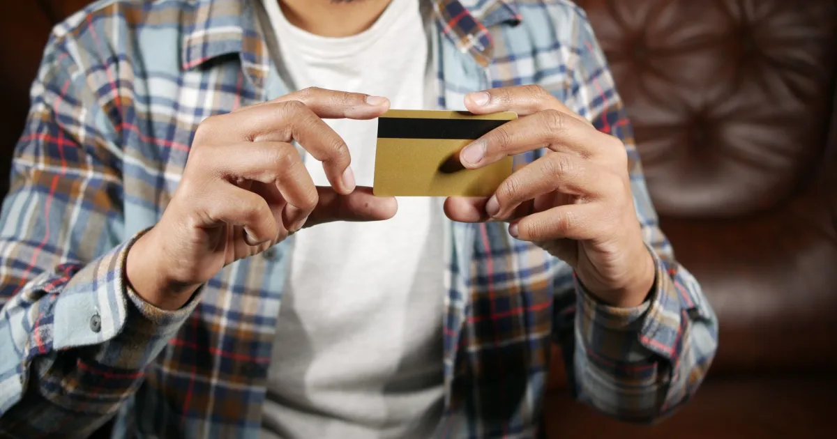 Choosing the best credit card for bad credit in Canada - man examining a plain gold card