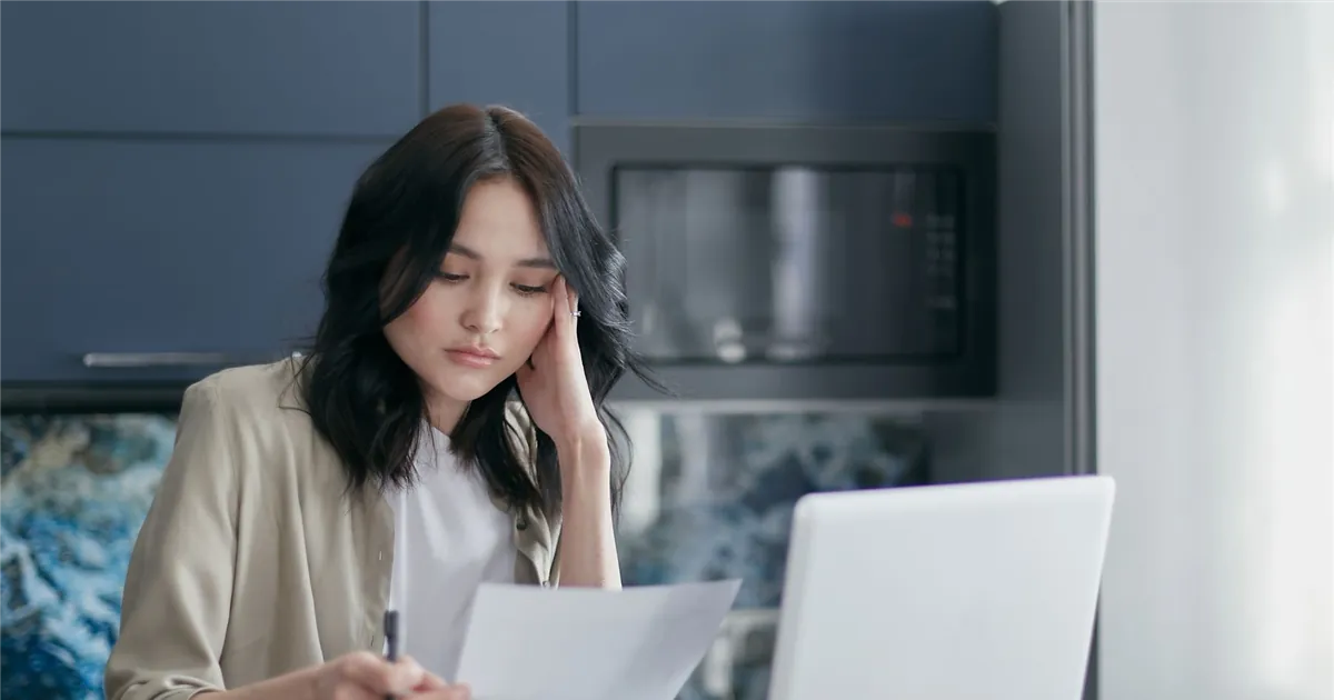 Woman reading a letter about her consumer proposal and the R7 rating on her credit report