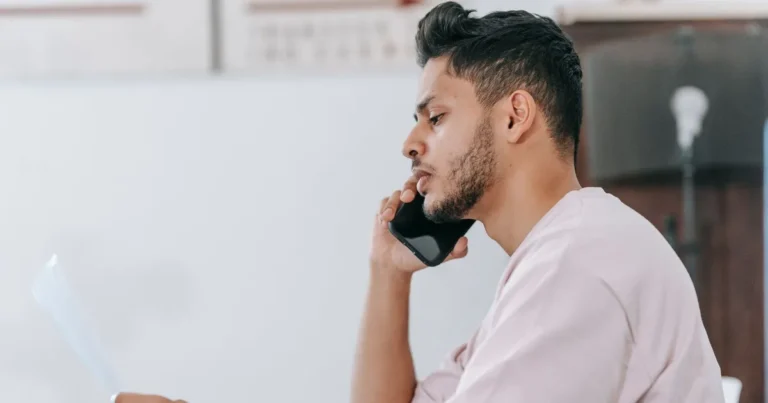 Man on the phone reading a CRA letter at his desk, working out which CRA debt forgiveness option applies to him