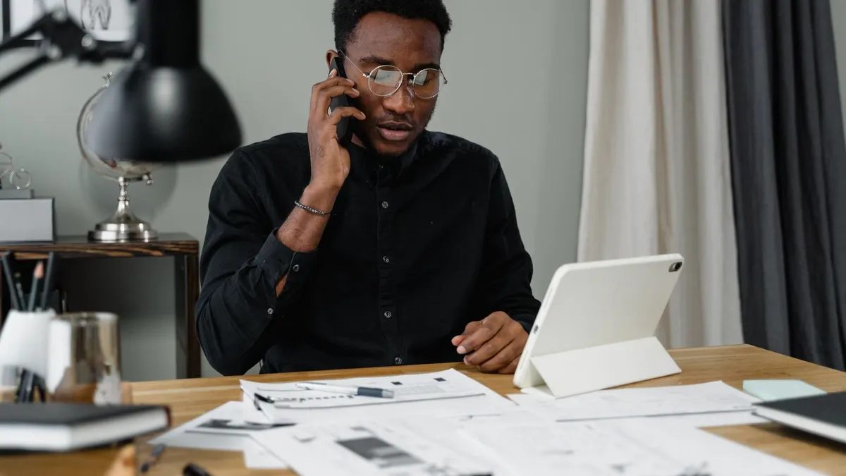 Man on the phone at his desk arranging a CRA payment plan after reading about CRA debt forgiveness