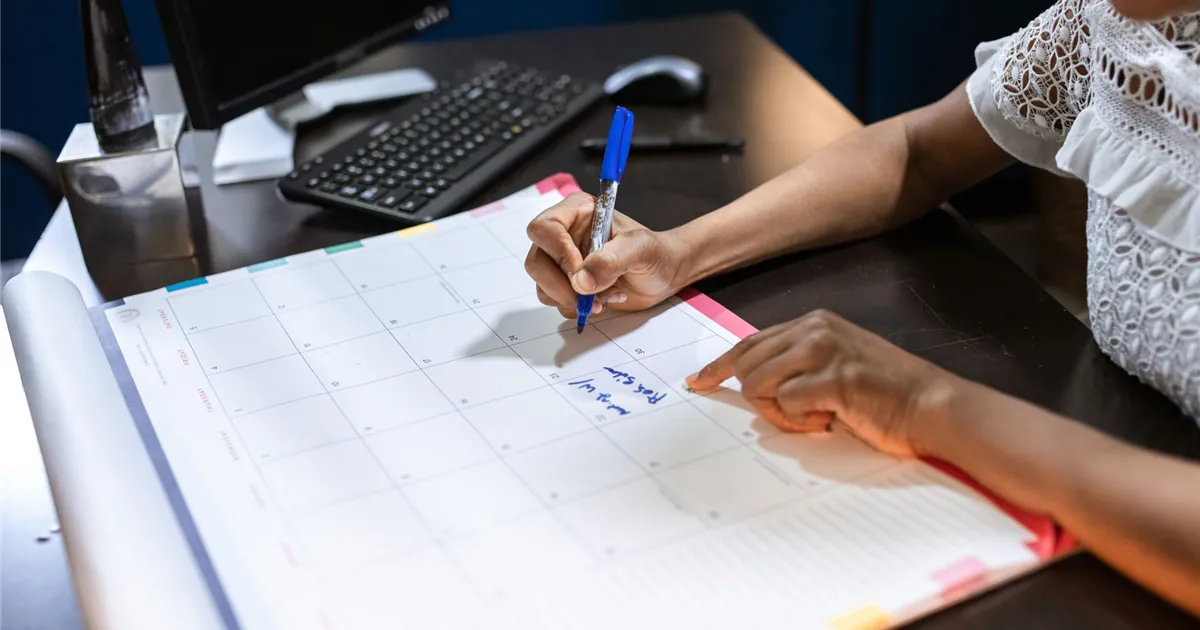 Marking a bill due date on a desk calendar to avoid a reportable late payment