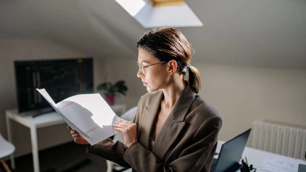 Woman reading her credit report line by line before filing a credit repair dispute in Canada